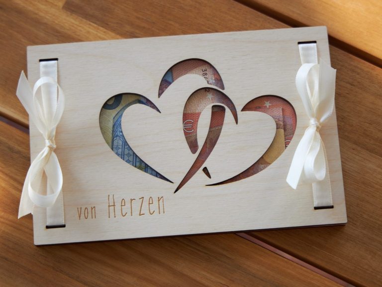 Holz Geschenkkarte zum verpacken von Geldscheinen mit einer Gravur von Herzen und ausgeschnittenen Herzen.