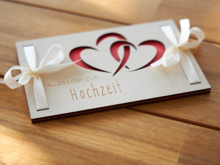 Holz Geschenkkarte zum verpacken von Geldscheinen mit einer Gravur von Herzen und ausgeschnittenen Herzen.